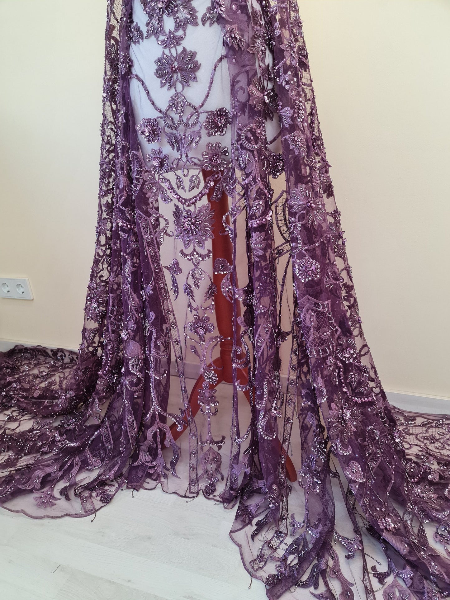 purple lace fabric draped on dressform from lower part