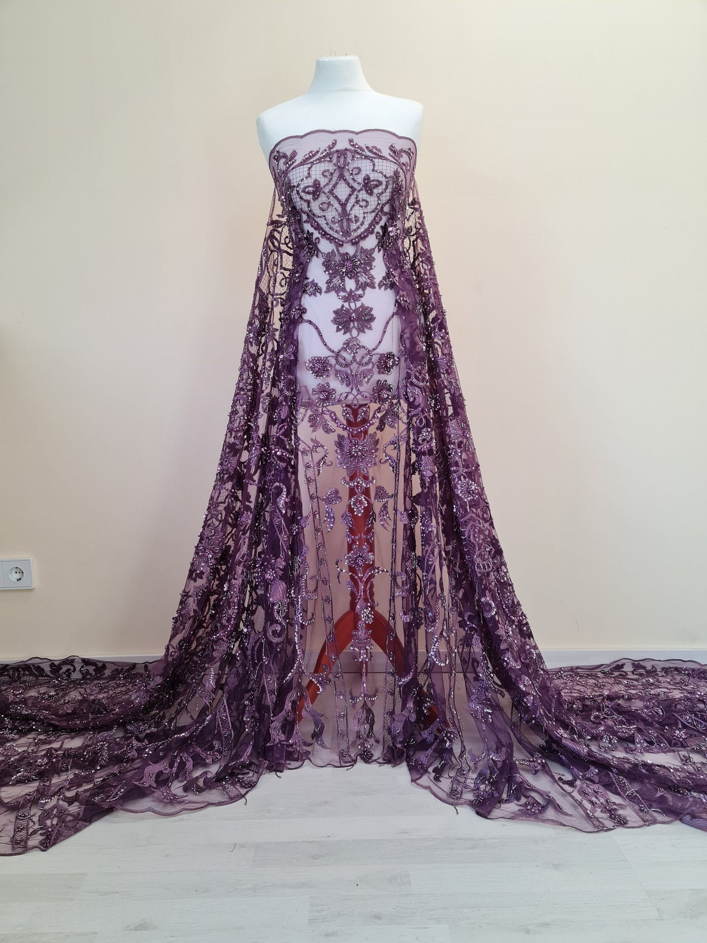 beaded lace fabric in purple color draped on dressform