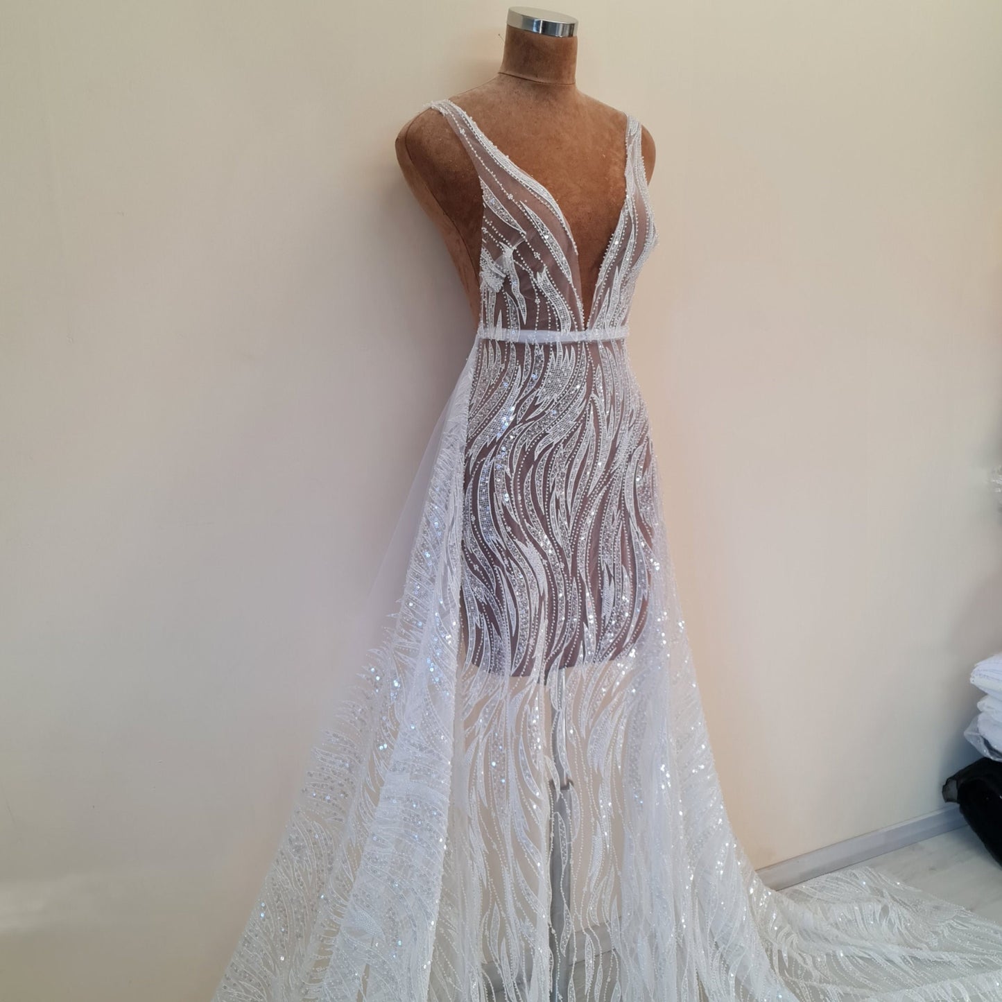 NahaufnahmeSpitzenstoff mit Wellen als Kleid mit schmalen Trägern drappiert