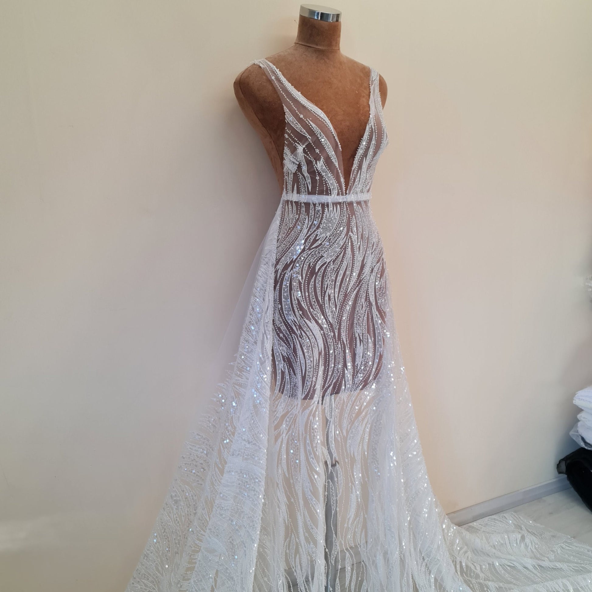 NahaufnahmeSpitzenstoff mit Wellen als Kleid mit schmalen Trägern drappiert