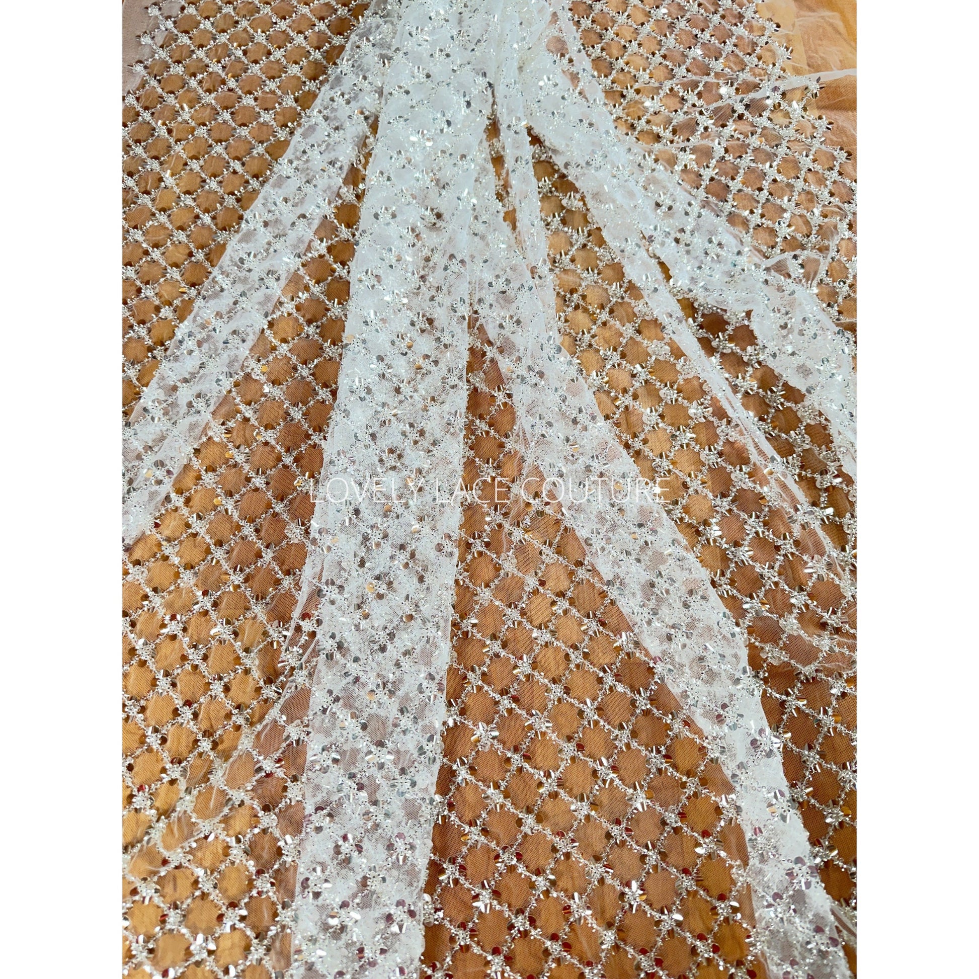 lace fabric with brown background shows the beautiful off-white color of the lace