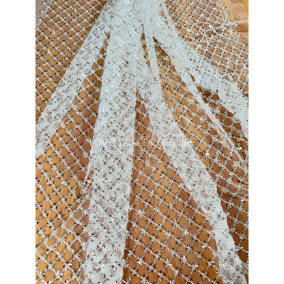 lace fabric with brown background shows the beautiful off-white color of the lace