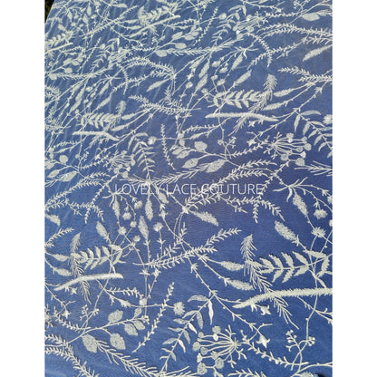 lace fabric with transparent buggle beads and sequins in white color on a blue background
