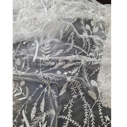 lace fabric with transparent buggle beads and sequins in white color, closer picture of the design shown on a black background