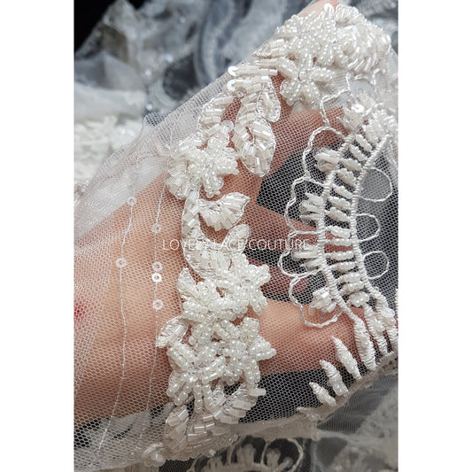 lace fabric with beads and sequins shown on hand
